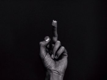 Close-up of hand holding hands against black background