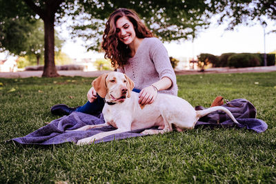 Portrait of woman with dog on grass