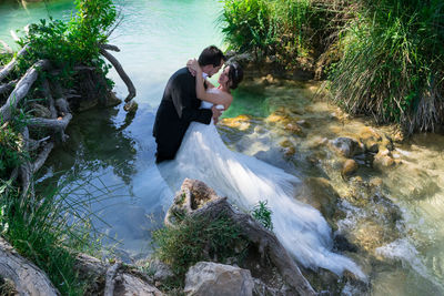 High angle view of wedding couple posing in river