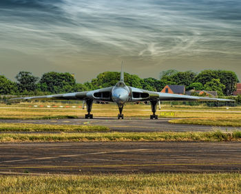 Airplane on field against sky