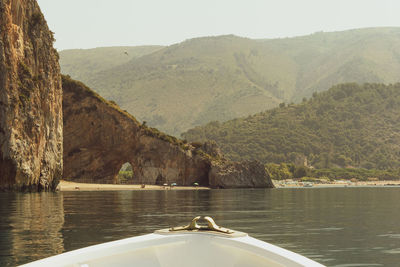 Scenic view of lake by mountains against sky