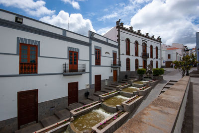 Houses by street against sky in city