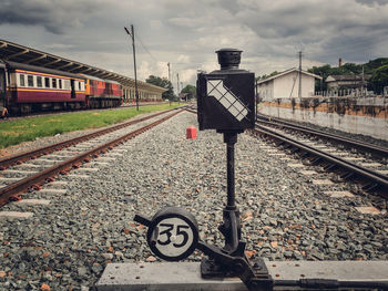 Machinery at railroad track against sky