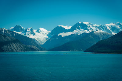 Scenic view of snowcapped mountains against blue sky