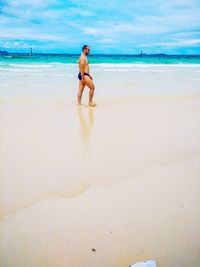 Full length of shirtless man on beach