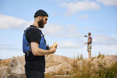 Man standing on coast and peeling banana