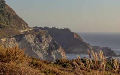 Scenic view of sea and mountains against clear sky