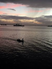 Silhouette boat sailing on sea against sky during sunset