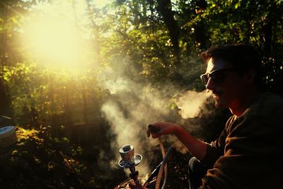 Side view of young man smoking outdoors