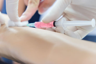 Close-up of nurse treating patient with injection