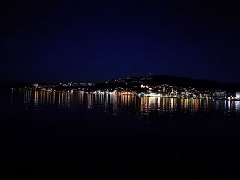 Illuminated cityscape against clear sky at night