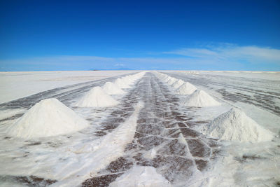 Panoramic view of desert land against blue sky