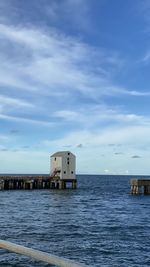 Scenic view of sea by building against sky