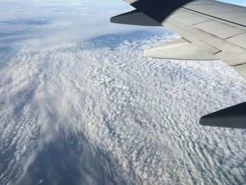 Aerial view of clouds over landscape seen from airplane