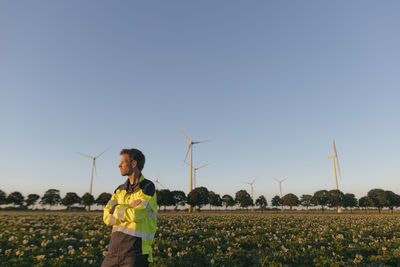 Engineer standing in a field at a wind farm