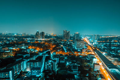 High angle view of illuminated buildings against clear sky at night