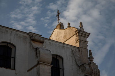 Low angle view of statues on building against sky
