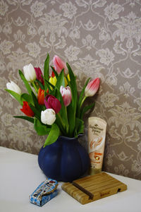 Close-up of flower vase on table against wall