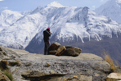 Man standing against snowcapped mountain