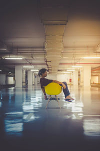 Woman sitting in illuminated building