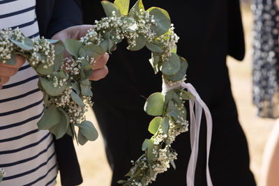 Midsection of woman holding flowering plant