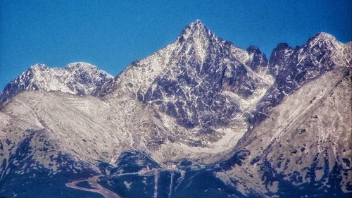 Panoramic view of snowcapped mountains against blue sky