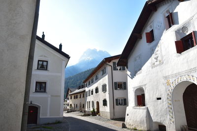 Street amidst houses and buildings against sky