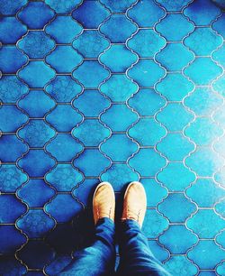 Low section of person standing on tiled floor