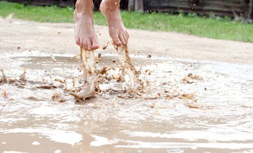 Low section of person standing in mud