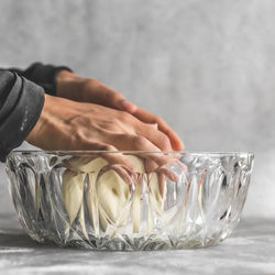 Close-up of hand holding glass bowl on table