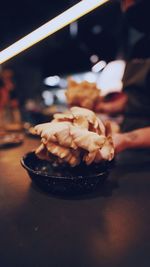 Close-up of hand holding ice cream on table