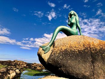 Low angle view of statue against rock
