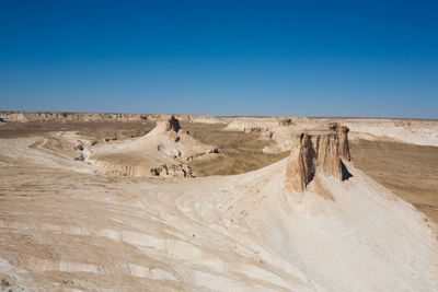 Scenic view of desert against clear blue sky