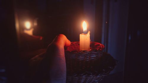 Close-up of lit candle in darkroom