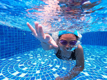 Girl swimming underwater in pool