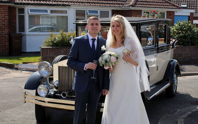 Portrait of bride holding bouquet, in company with groom and champagne 