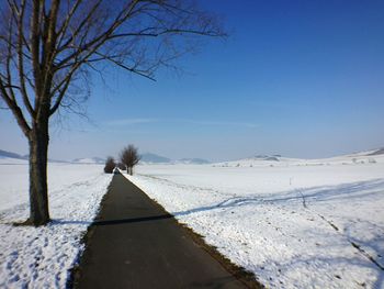 Snow covered landscape against clear sky