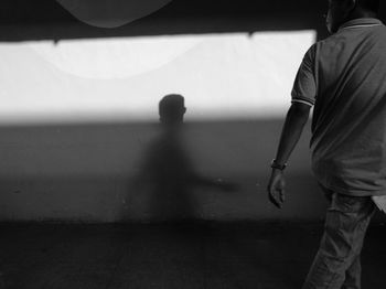 Reflection of man walking against mirror