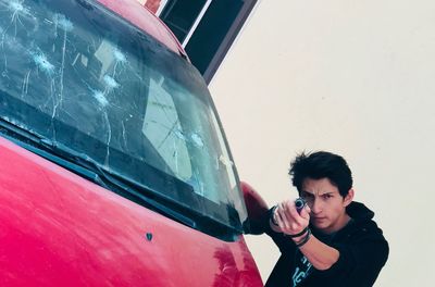 Portrait of young man standing in car