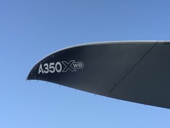 Low angle view of information sign against clear blue sky