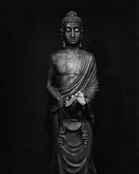 Statue of buddha against black background