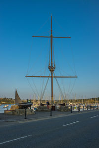 Sailboats in city against clear blue sky