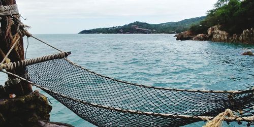 View of fishing net on sea against sky