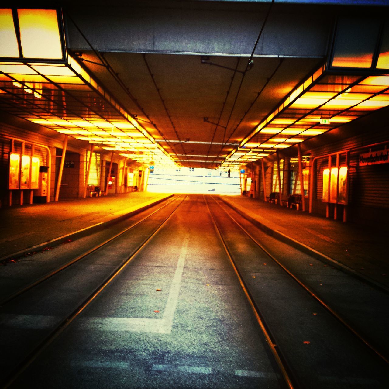 illuminated, railroad track, transportation, railroad station, railroad station platform, indoors, public transportation, rail transportation, the way forward, diminishing perspective, architecture, built structure, subway station, empty, subway, ceiling, vanishing point, public transport, travel, lighting equipment