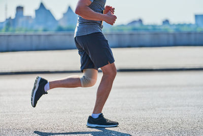 Running man. athletic man jogging in sportswear on city road. street workout, sprinting outdoor