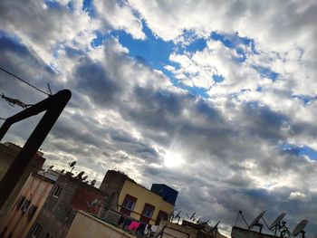 Low angle view of buildings against cloudy sky