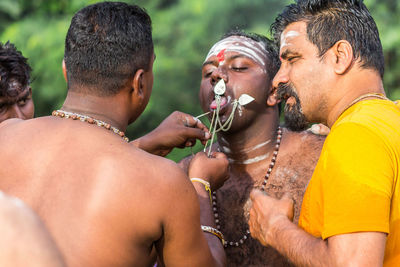 Midsection of young man drinking outdoors