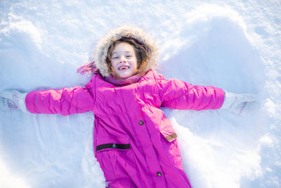 Portrait of smiling young woman standing on snow