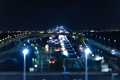 Illuminated bridge against sky at night