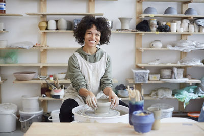 Portrait of smiling woman learning pottery in art studio